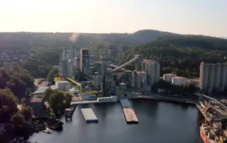 Industrial factory by river with smokestacks