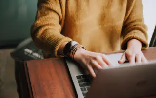 Hands typing on laptop keyboard